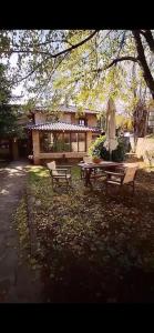 einem Picknicktisch und einem Regenschirm vor einem Haus in der Unterkunft Helydorea zen in Synikia Mesi Trikalon