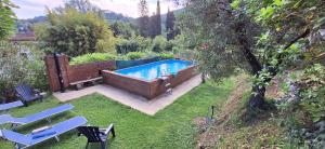 una piscina en un patio con sillas en Il Fienile, en Ripafratta
