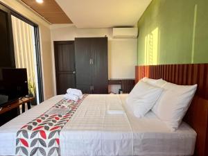 a bedroom with a large bed with white pillows at Mula De La Paz in Zambales