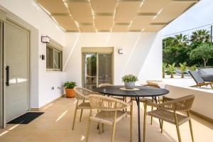 a dining room with a table and chairs at Phillyrėa Luxury Villas in Kos Town