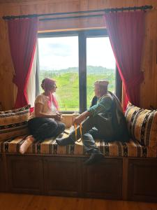 un hombre y una mujer sentados en el alféizar de una ventana en Rino hauss, en Fındıklı