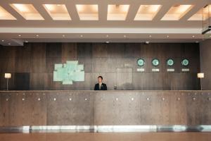 a man standing behind a counter in a lobby at Holiday Inn Abu Dhabi, an IHG Hotel in Abu Dhabi