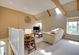 uma sala de estar com um sofá e uma mesa em The Coach House - Norfolk em Oxborough