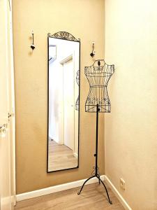 Um espelho numa parede com um manequim à frente. em Apartamento DACTONIUM - Ribeira Sacra em Monforte de Lemos