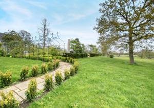 um jardim com um caminho num campo em The Coach House - Norfolk em Oxborough