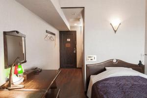 a bedroom with a bed and a desk with a mirror at Okazaki Ohwa Hotel in Okazaki