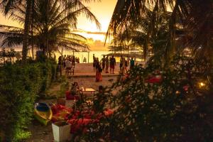 un grupo de personas caminando por la playa al atardecer en Echo Beach Hostel, en Baan Tai