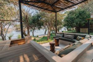 a living room with a couch on a wooden deck at Nuyanaya River Camp in Chiawa
