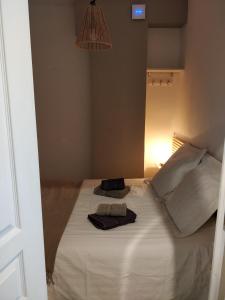 a bedroom with a bed with white sheets and a lamp at Le Palais du Tropique in Juan-les-Pins