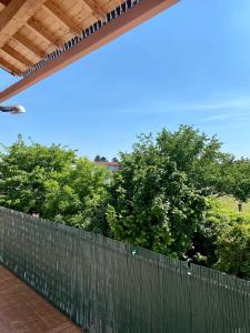 une clôture avec des arbres en arrière-plan et un ciel bleu dans l'établissement Ruti's House, à Cassano Magnago