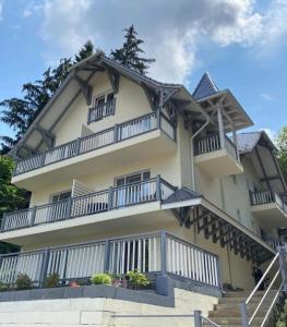 - un grand bâtiment blanc avec un balcon et des escaliers dans l'établissement Vila Niki, à Sovata