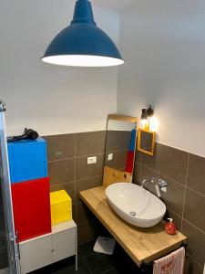 a bathroom with a sink and a blue light at Ruti's House in Cassano Magnago