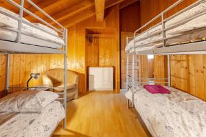 two bunk beds in a room with wooden walls at Chalet Etoile in Saint-Jean-d'Aulps