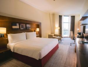 um quarto de hotel com uma cama grande e uma secretária em Holiday Inn Abu Dhabi, an IHG Hotel em Abu Dhabi