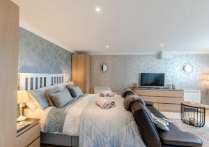 - une chambre avec un grand lit et une télévision dans l'établissement Highridge Apartment, à Wooler
