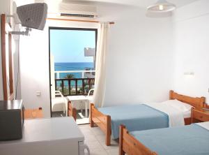 a room with two beds and a view of the ocean at Hotel Thisvi in Stalís