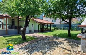 una casa con un jardín y dos árboles en Simada Green Guesthouse, en Varshets