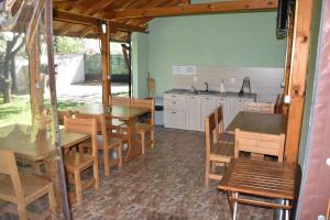 a kitchen with wooden tables and chairs and a sink at Simada Green Guesthouse in Varshets +30 photos