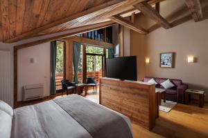 a bedroom with a bed and a flat screen tv at Teleferic Grand Hotel in Poiana Brasov