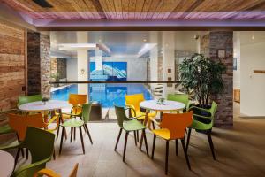 a restaurant with tables and chairs and a swimming pool at Teleferic Grand Hotel in Poiana Brasov +122 photos
