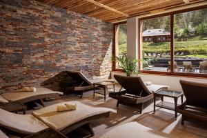 a living room with chairs and a brick wall at Teleferic Grand Hotel in Poiana Brasov