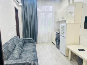 a living room with a couch in a kitchen at Apartments NITA in Batumi