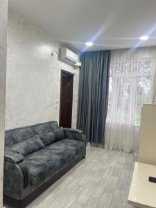 ein Wohnzimmer mit einem Sofa und einem Fenster in der Unterkunft Apartments NITA in Batumi