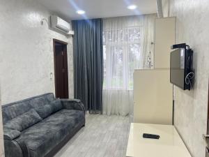 a living room with a couch and a tv at Apartments NITA in Batumi