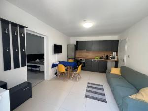 a living room with a blue couch and a kitchen at NassaFlat Apartman in Pécs