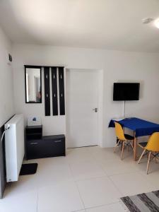 a living room with a blue table and yellow chairs at NassaFlat Apartman in Pécs