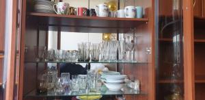 a shelf filled with glasses and bowls and plates at Family Villa Sarapin in Kretinga +16 photos