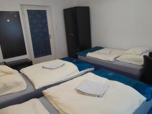 um quarto com três camas com toalhas em Kék Vándor Vendégház 