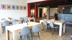 um restaurante com mesas de madeira e cadeiras azuis em Plaza Inn Braunschweig City Nord em Braunschweig
