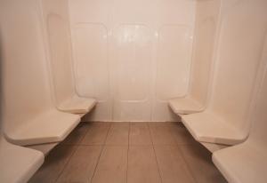 a row of urinals in a bathroom with tile floors at Holiday Inn Abu Dhabi, an IHG Hotel in Abu Dhabi