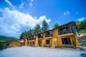 ein großes gelbes Gebäude mit großem Parkplatz in der Unterkunft Haghartsin Hotel and Restaurant in Dilidschan