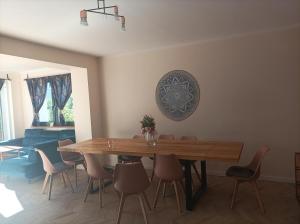 a dining room with a wooden table and chairs at Dom Gdansk Przymorze 7 pokoi mini SPA in Gdańsk