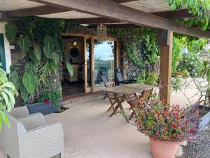 a patio with a wooden table and chairs and flowers at appartamento in Pantelleria