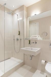 a white bathroom with a sink and a shower at Hotel Johann in Berlin