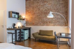 a living room with a brick wall and a chair at Hotel Johann in Berlin