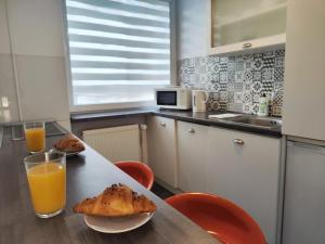 a kitchen with a table with bread and orange juice at Willa Joanna in Gdańsk