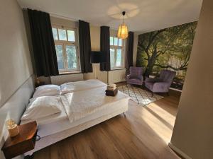 a bedroom with a bed and two chairs at De Arcense Herberg in Arcen