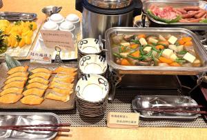 - un buffet de plats avec des légumes et de la viande sur une table dans l'établissement Hotel Courtland, à Nagano