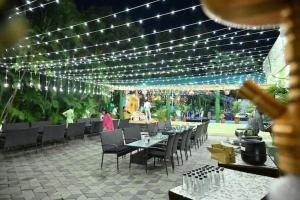 zona de comedor con mesas, sillas y luces en Shankars Motel The Royal Regalia, Bhopal en Phanda