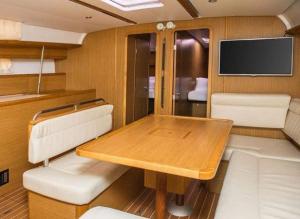 a dining room with a wooden table and a tv at Bed on Boat 32021 corfu in Agios Rokkos