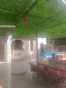 Airkela Nuba Dool2 في أسوان: غرفة ذات سقف أخضر مع كراسي وطاولة