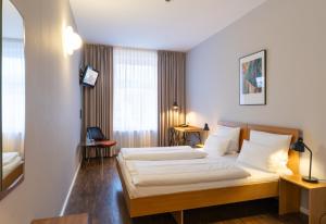 um quarto de hotel com uma cama e uma janela em Hotel Johann em Berlim