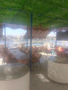 um restaurante com mesas e cadeiras e tecto verde em Airkela Nuba Dool2 em Aswan