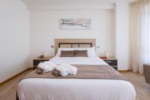 Un dormitorio con una cama grande con dos perros. en Alojamientos Rías Baixas - Casa Lisi - Ribeira en Ribeira