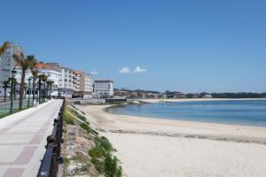 una playa junto al agua con edificios en Alojamientos Rías Baixas-Casa Lisi-Ribeira, en Ribeira