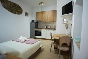 ein Schlafzimmer mit Bett und Tisch und eine Küche in der Unterkunft Studio GabAmi in Koper + 6 Fotos